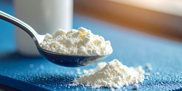 Scoop of creatine monohydrate powder on a blue gym mat, natural light — Hyperforme Nutrition